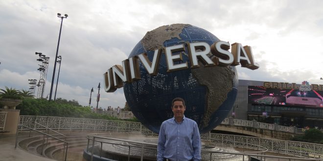 marcos paes de barros posa diante de uma escultura do globo da universal no complexo da marca em Orlando