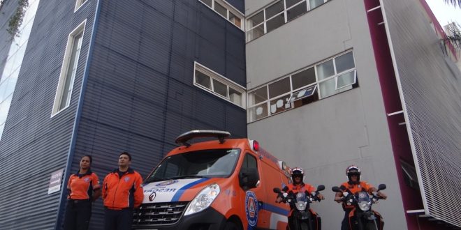 dois agentes da defesa civil de barueri posam em suas motos ao lado de uma van do órgão com duas outras agentes posando ao lado