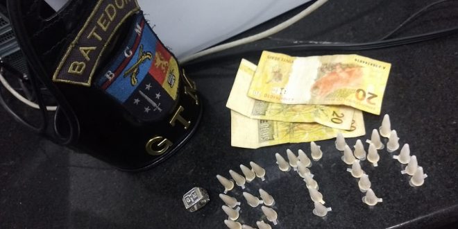 pinos de cocaina dispostos de modo a formar a sigla GTM e cédulas de dinhiro dispostos sobre uma mesa