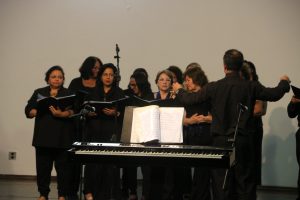 mulheres cantando diante de um piano