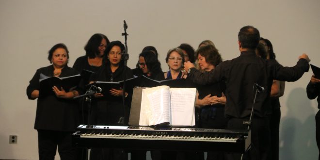 mulheres cantando diante de um piano