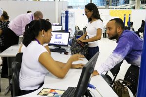 uma mulher atende um homem numa mesa em meio a várias outras