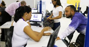 uma mulher atende um homem numa mesa em meio a várias outras