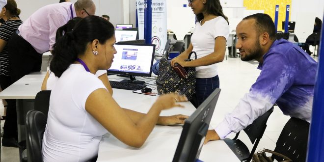 uma mulher atende um homem numa mesa em meio a várias outras